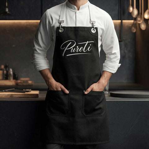 Person wearing a black apron with 'Pureti' branding in a kitchen setting