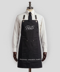 Black apron with 'Pureti' branding on a mannequin against a white background
