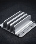 PureTi aluminium cutting board stand with three slots, angled view on a black fabric background