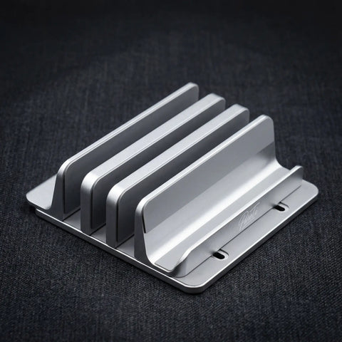 PureTi aluminium cutting board stand with three slots, angled view on a black fabric background