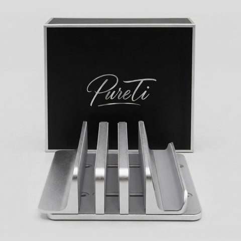 Aluminium cutting board stand with 'PureTi' branding on a black box in the background