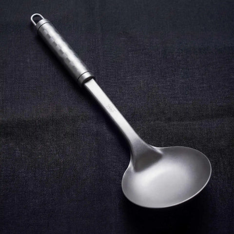 PureTi titanium solid spoon on a black fabric background