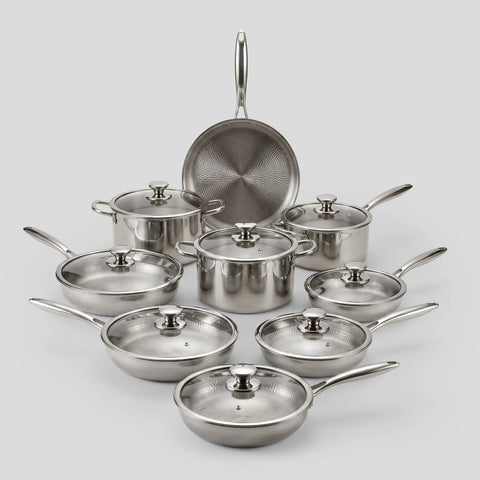PureTi titanium cookware set of hammered pans and pots with glass lids on a light gray background