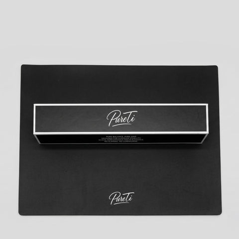 Black box with 'Pureti' branding on a matching black silicon mat against a light gray background