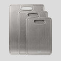 Three PureTi titanium cutting boards in small, medium and large sizes on a light gray background