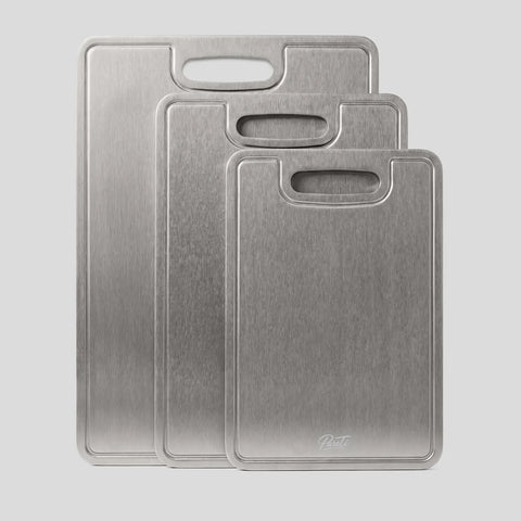 Three PureTi titanium cutting boards in small, medium and large sizes on a light gray background
