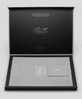 Open black box and gray sleeve for the PureTi titanium cutting board with 'PureTi' branding on a light gray background