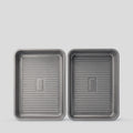 Two PureTi titanium baking trays with ridged bases, top view on a light gray background